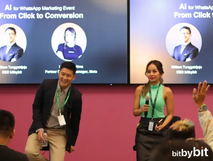 Two speakers on stage at the AI for WhatsApp Marketing event, panel slide visible behind